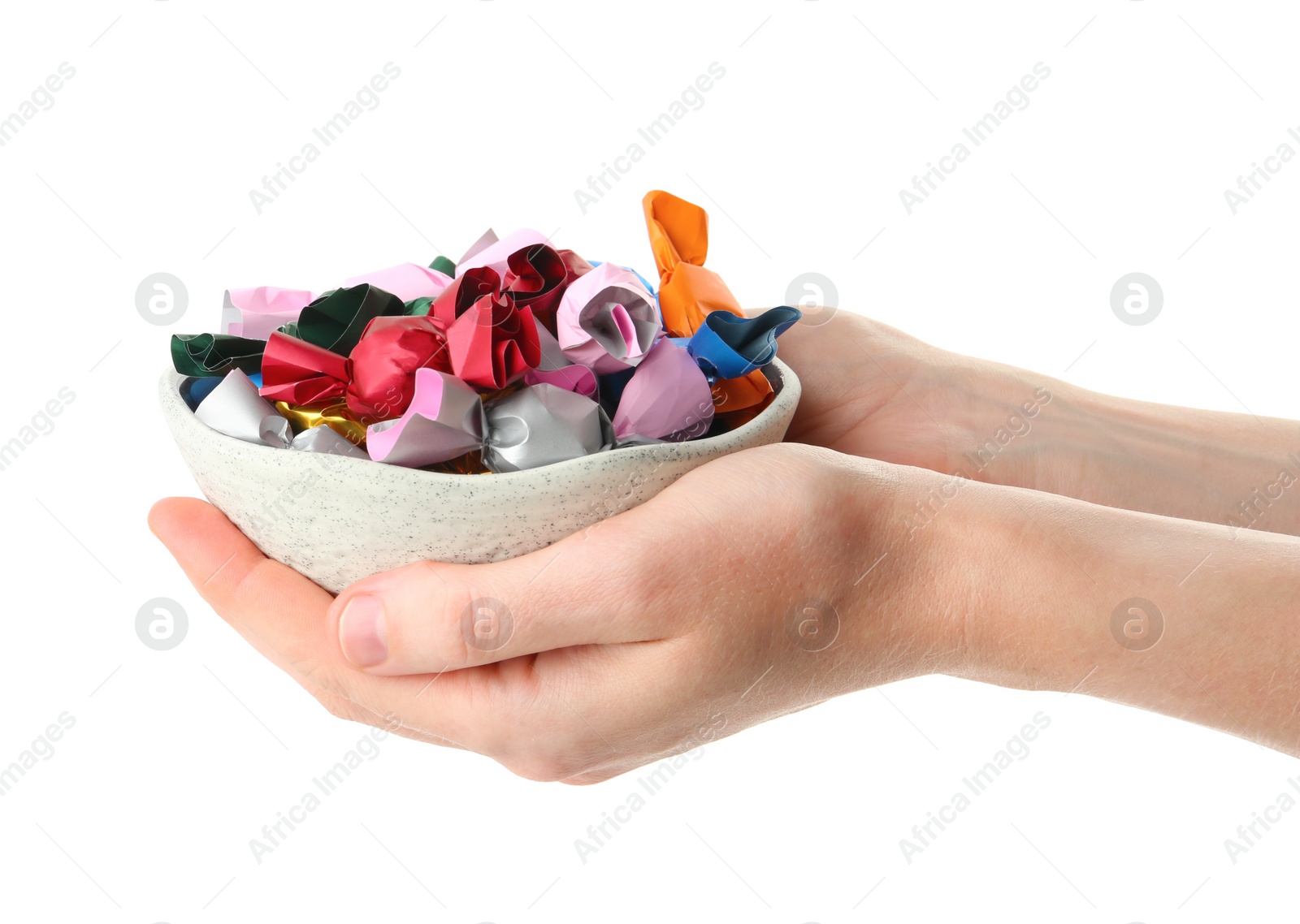 Photo of Woman holding bowl with candies in colorful wrappers isolated on white, closeup