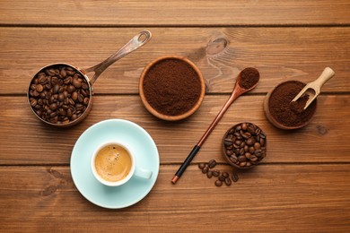 Flat lay composition with coffee grounds and roasted beans on wooden table