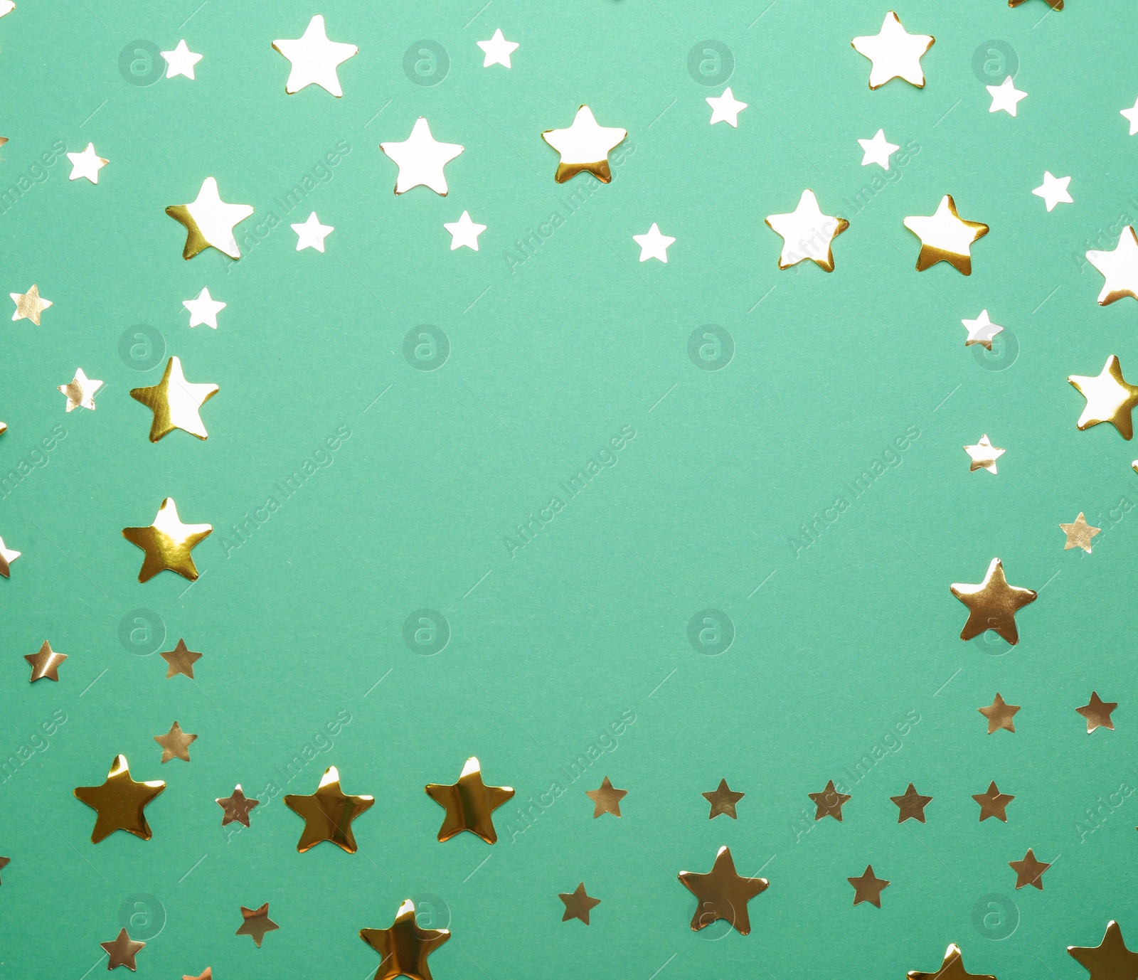 Photo of Frame made of confetti stars with space for text on green background, top view. Christmas celebration