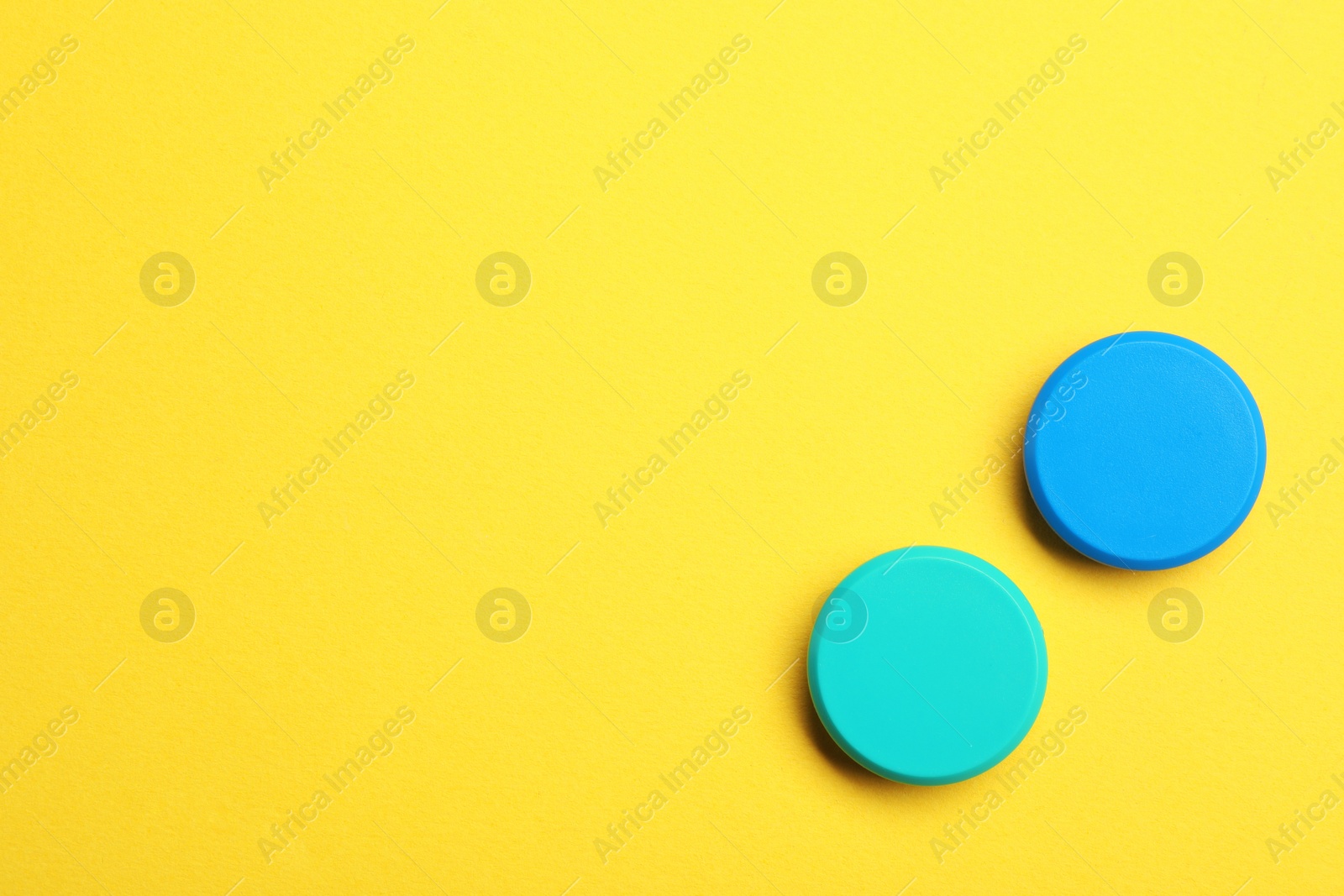 Photo of Bright magnets on color background, top view with space for text