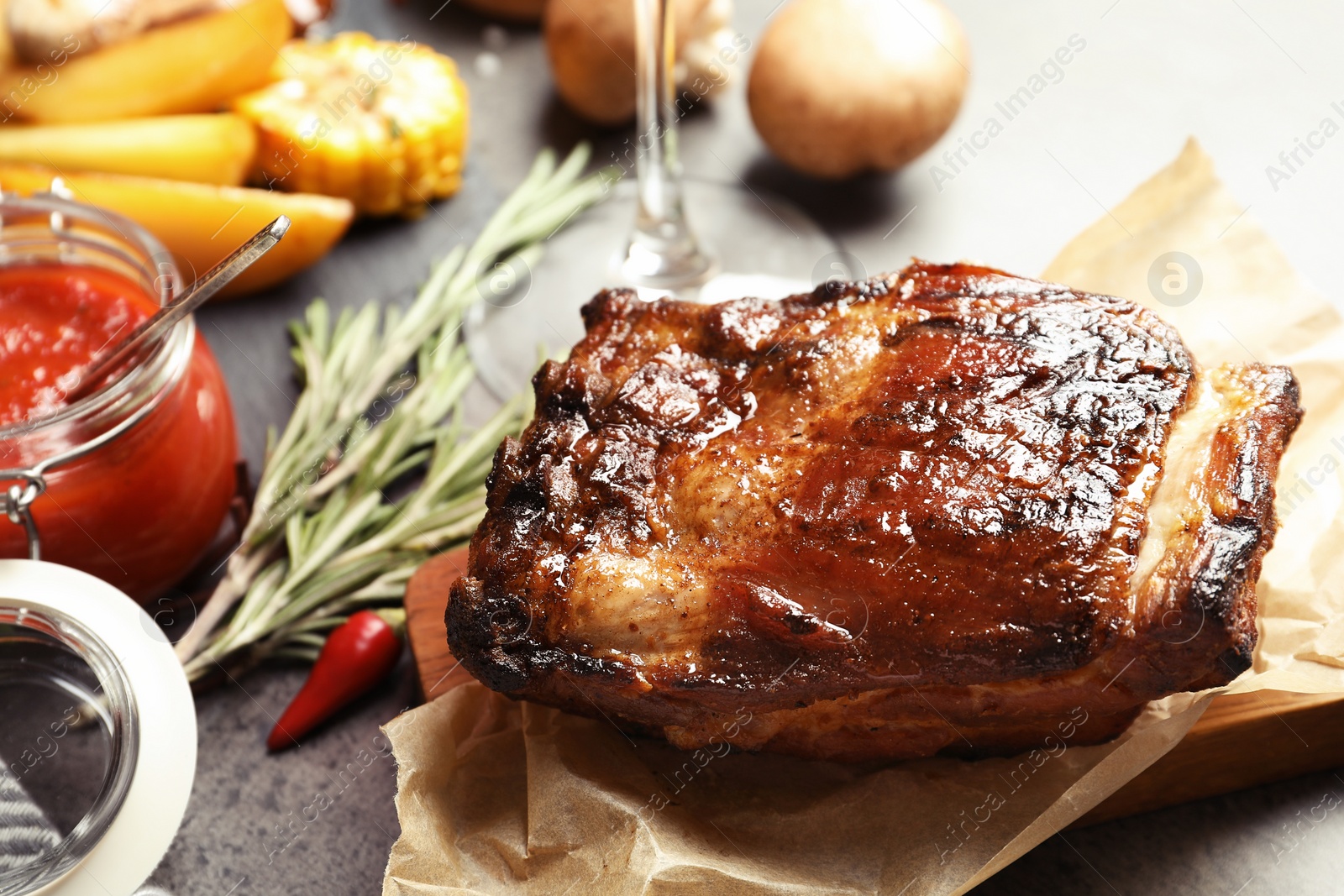 Photo of Piece of delicious barbecued ribs served on gray table