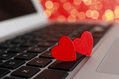 Photo of Decorative hearts on laptop keyboard, closeup. Online dating concept