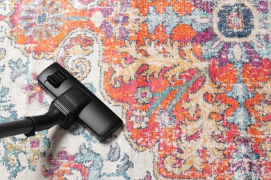 Photo of Hoovering carpet with modern vacuum cleaner, above view. Space for text