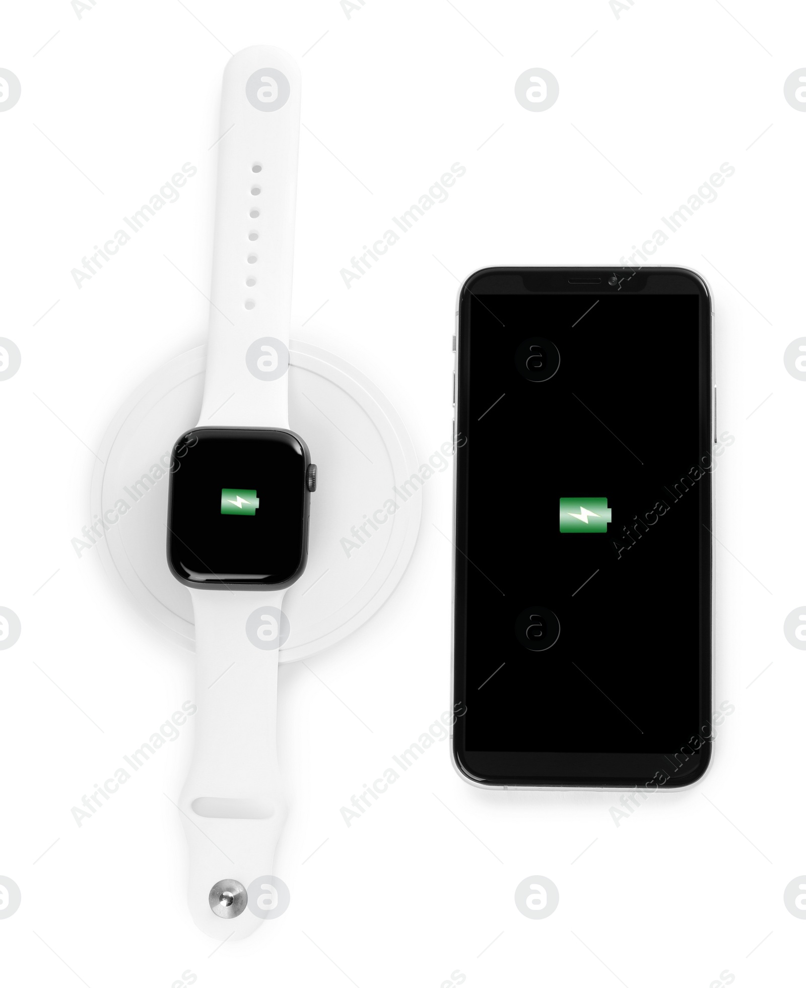 Photo of Smartwatch charging with wireless pad and mobile phone isolated on white, top view