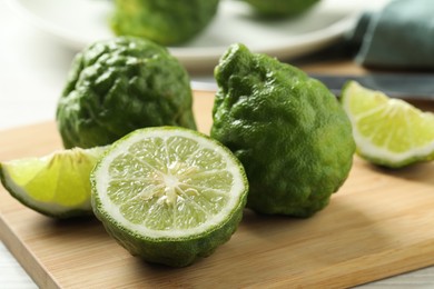 Whole and cut ripe bergamot fruits on wooden board, closeup