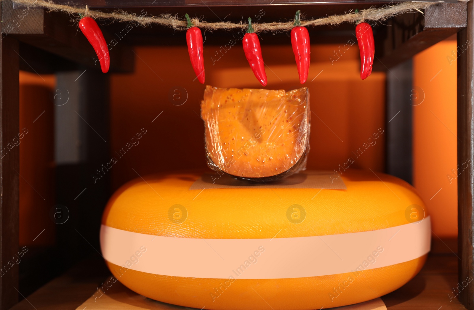 Photo of Delicious cheese on rack shelf in store. Dairy product