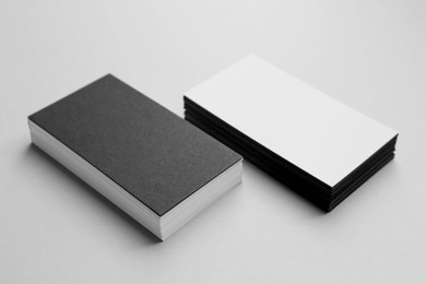 Photo of Blank black and white business cards on light background. Mockup for design