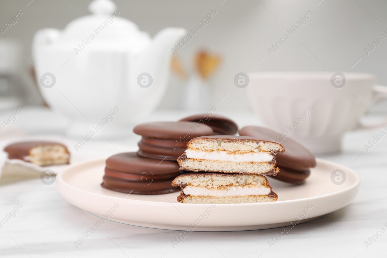 Photo of Plate with delicious choco pies on white marble table in kitchen