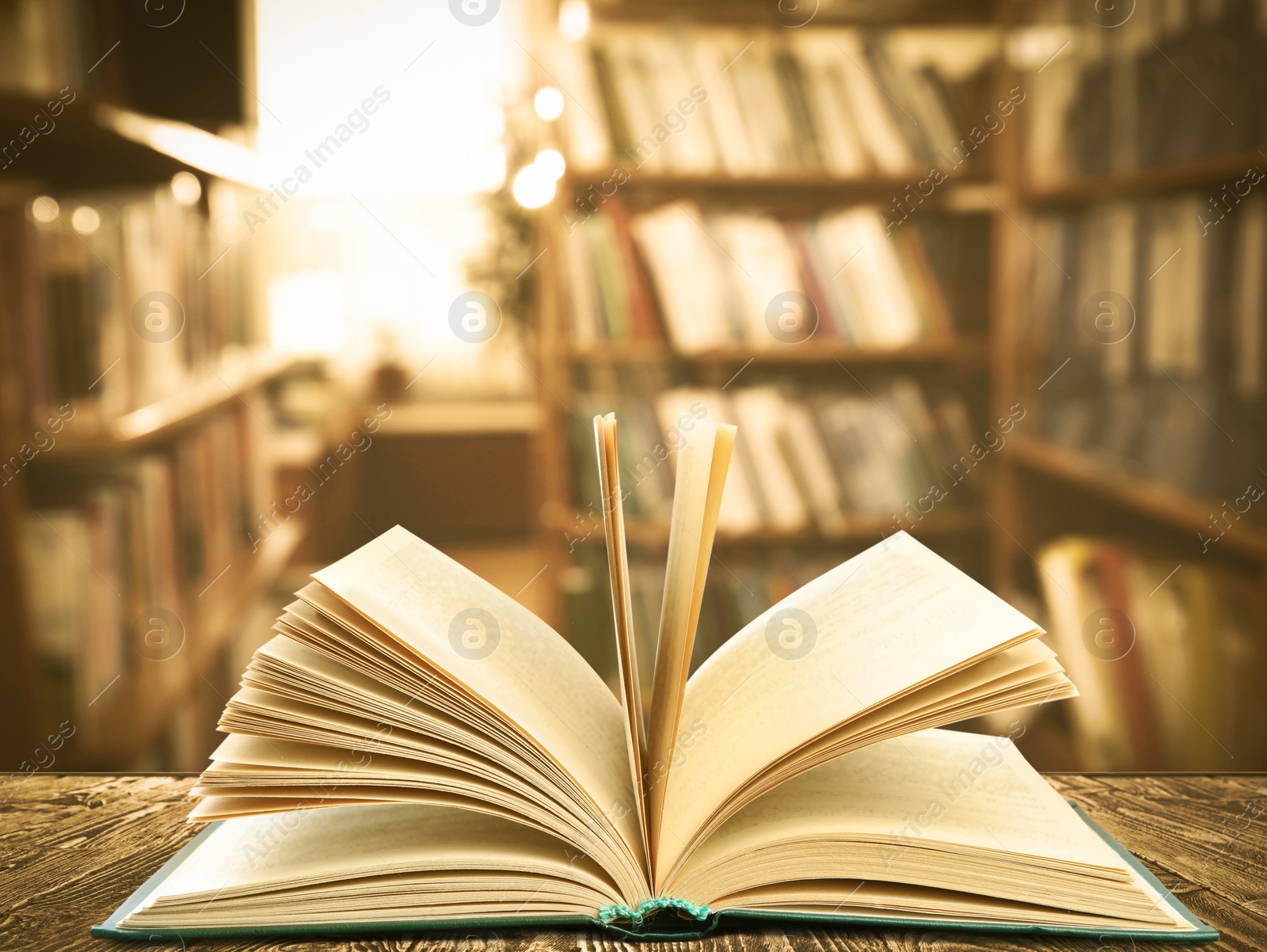 Image of Open book on wooden table in library