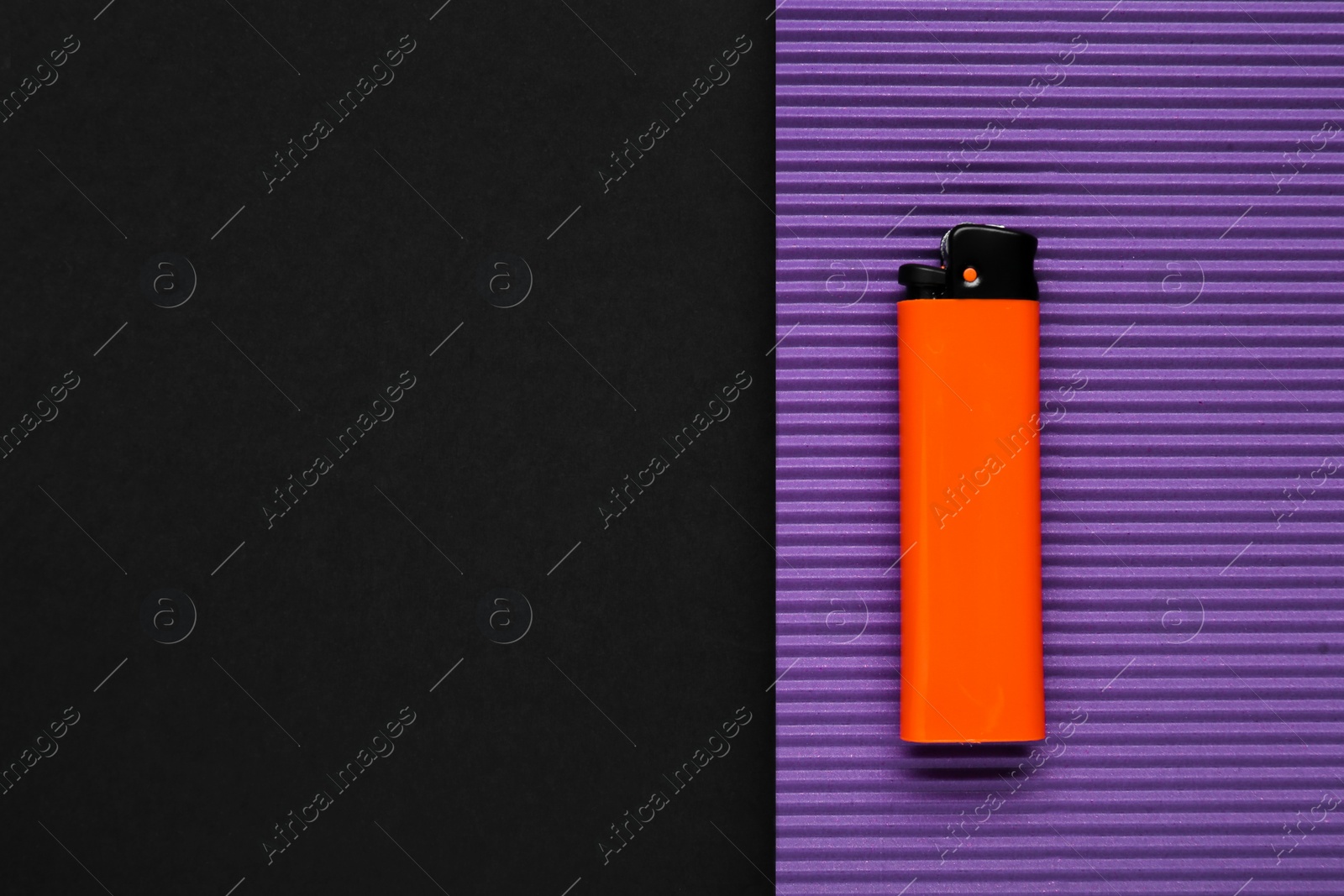 Photo of Stylish small pocket lighter and purple corrugated fiberboard on black background, top view. Space for text