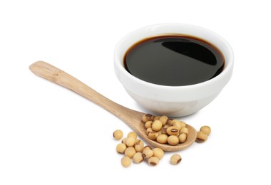 Tasty soy sauce in bowl, soybeans and spoon isolated on white