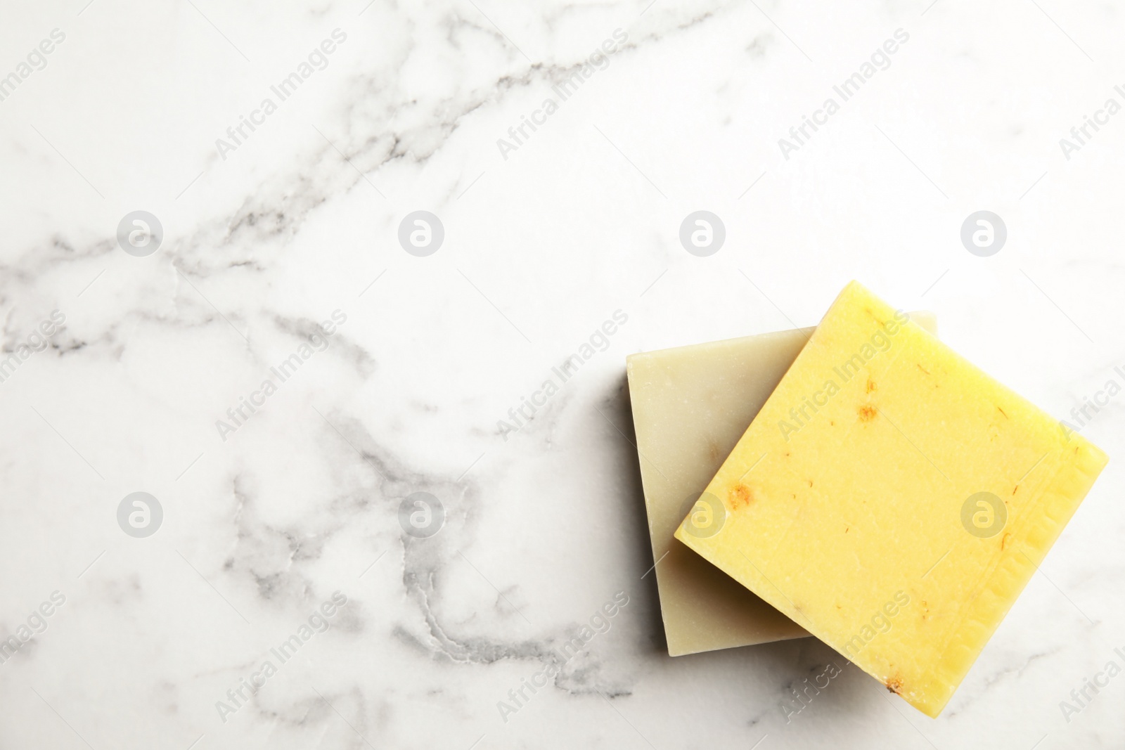 Photo of Hand made soap bars on marble background, top view. Space for text