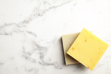 Photo of Hand made soap bars on marble background, top view. Space for text