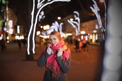 Photo of Beautiful young woman spending time in city at night