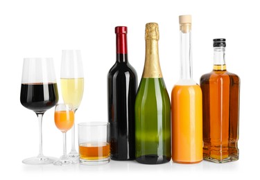 Photo of Bottles and glasses with different alcoholic drinks isolated on white