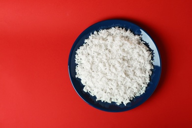 Photo of Plate of boiled rice on color background, top view with space for text