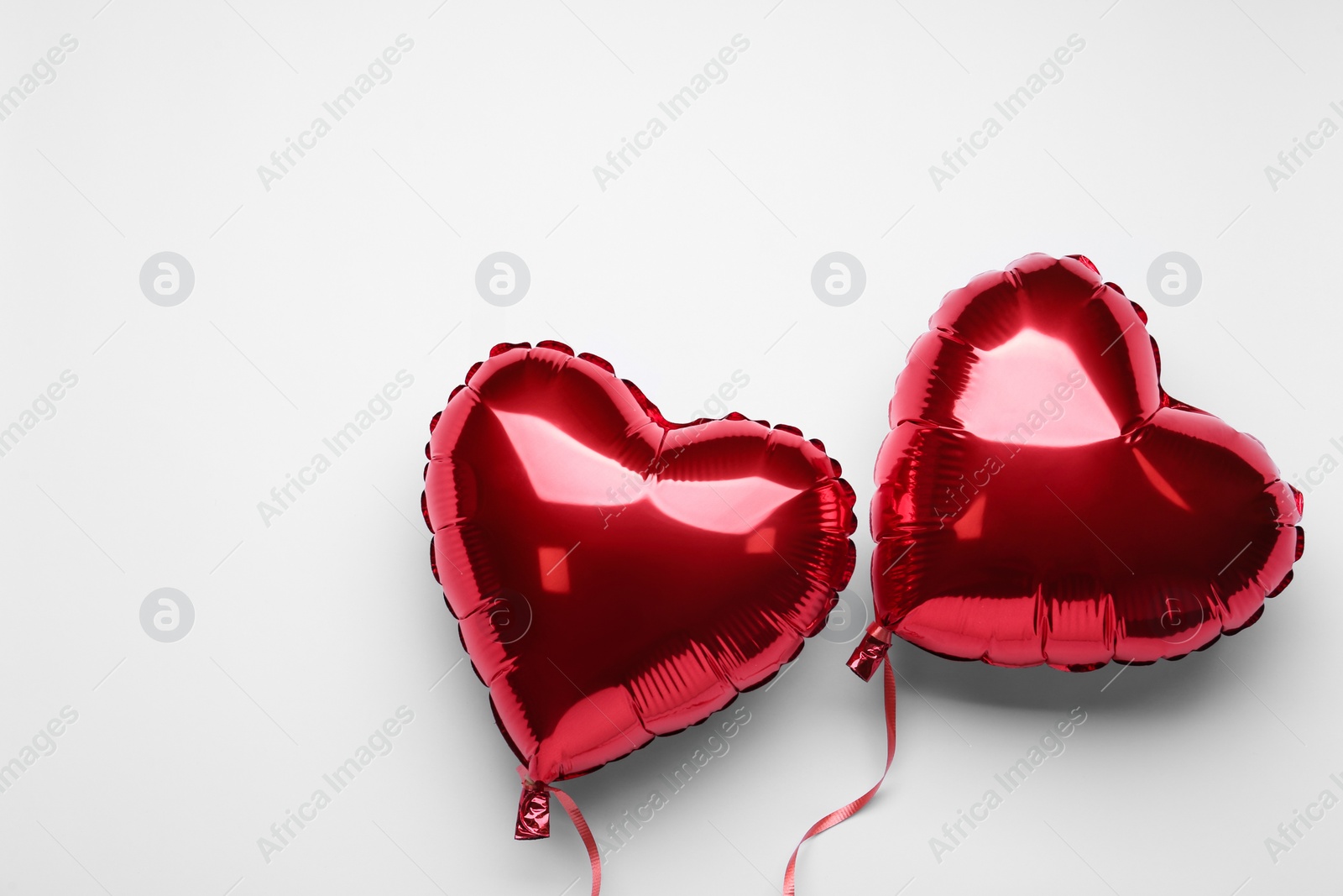 Photo of Red heart shaped balloons on white background, flat lay with space for text. Valentine's Day celebration