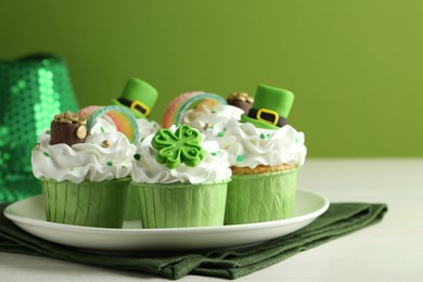 St. Patrick's day party. Tasty festively decorated cupcakes on white table, closeup