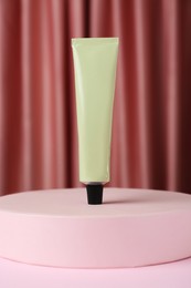 Photo of Tube of hand cream on pink table