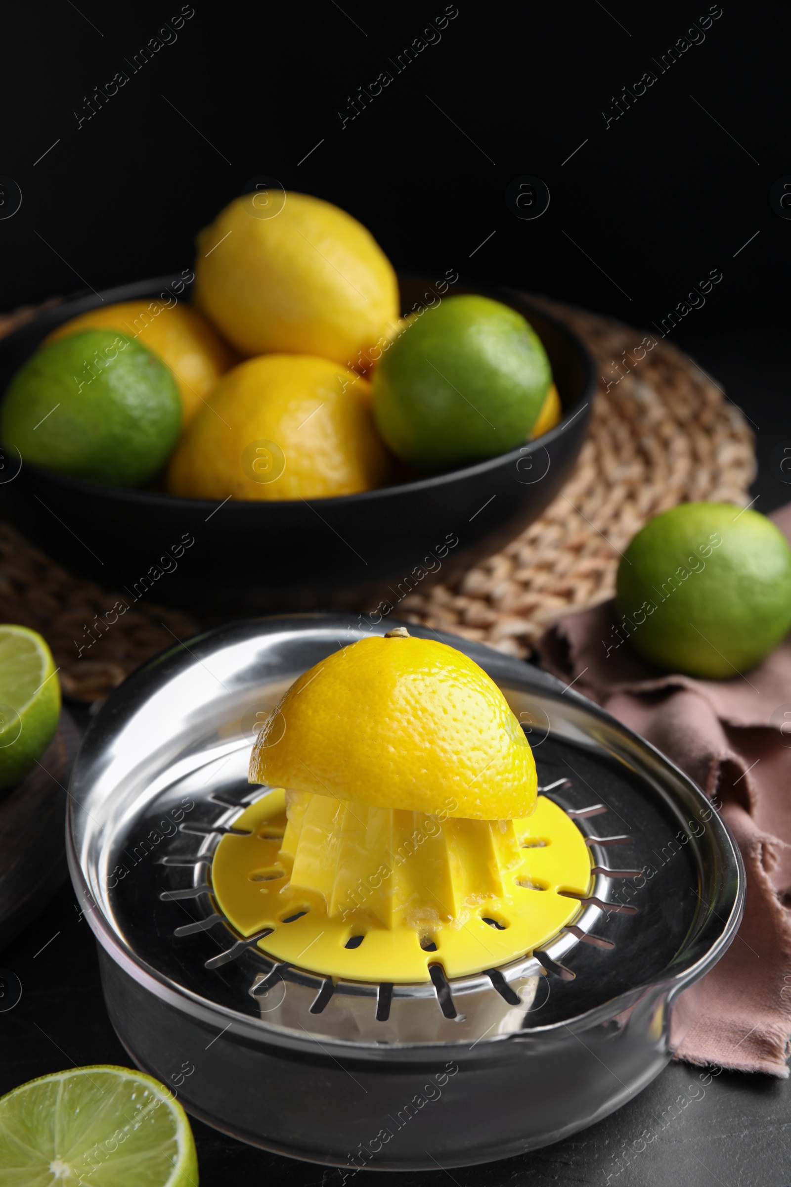 Photo of Squeezer, fresh lemons and limes on black table