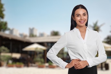 Image of Portrait of hostess in uniform and blurred view of restaurant on sunny day. Space for text