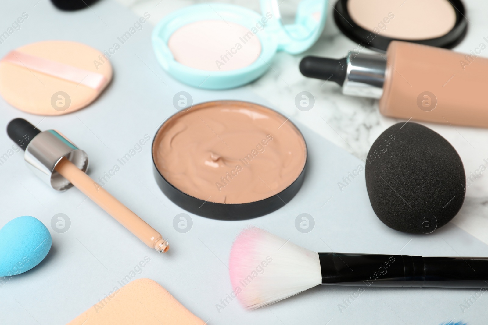 Photo of Composition with skin foundation and beauty accessories on white background