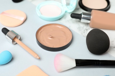 Composition with skin foundation and beauty accessories on white background