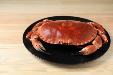 Photo of Plate with delicious boiled crab on wooden table
