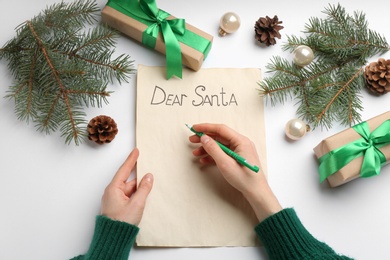 Top view of woman writing letter to Santa at white table, closeup