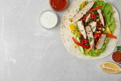 Photo of Delicious tortilla with meat on light table, flat lay. Space for text