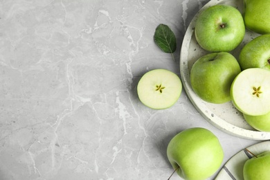 Photo of Flat lay composition of fresh ripe green apples on grey stone table, space for text