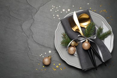 Photo of Festive table setting with beautiful dishware and Christmas decor on black background, flat lay. Space for text