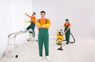 Team of professional janitors cleaning room after renovation