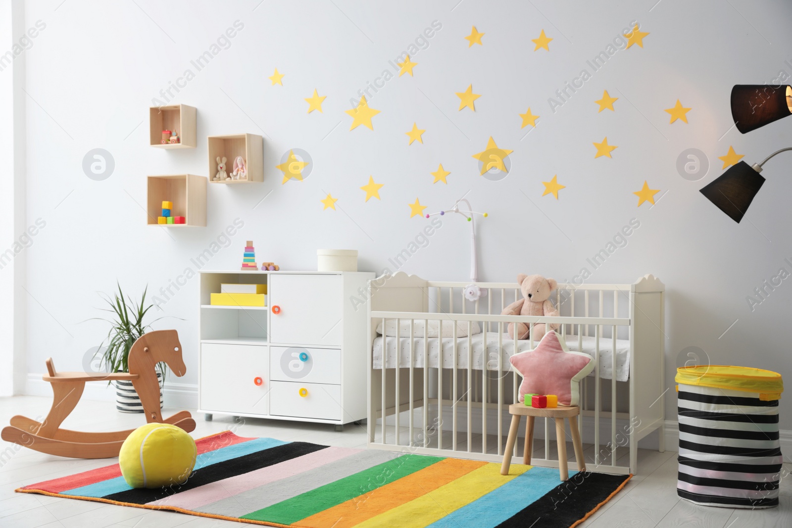 Photo of Stylish baby room interior with crib and toys