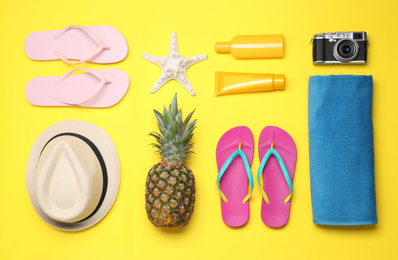 Photo of Beach accessories on yellow background, flat lay