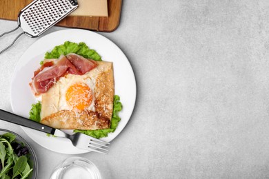 Photo of Delicious crepe with egg served on light gray table, flat lay with space for text. Breton galette