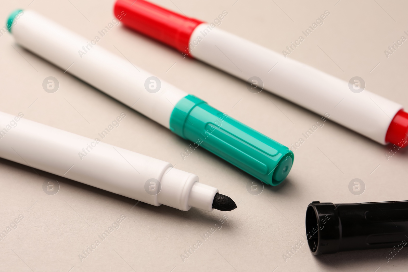 Photo of Bright color markers on beige background, closeup