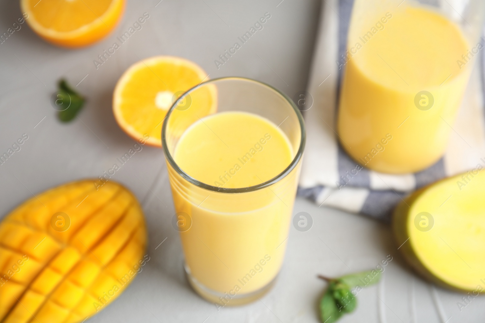 Photo of Fresh mango drink and tropical fruits on table