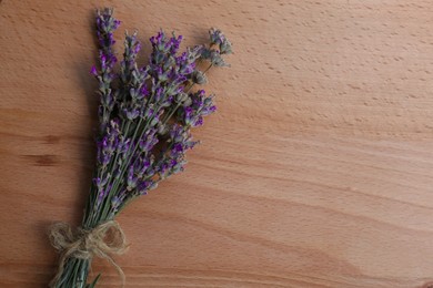 Photo of Bouquet of beautiful lavender flowers on wooden table, top view. Space for text
