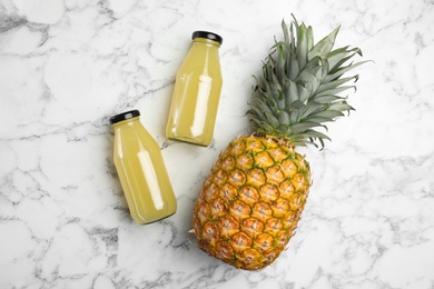 Delicious pineapple juice and fresh fruit on white marble table, flat lay