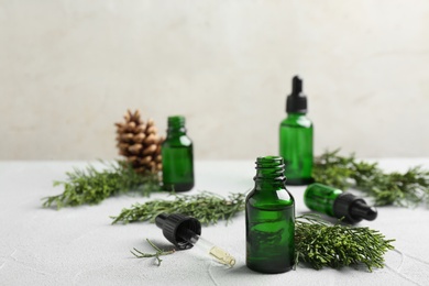 Photo of Composition with bottle of conifer essential oil on light table. Space for text