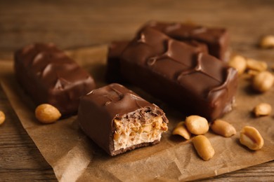 Photo of Chocolate bars with caramel, nuts and nougat on table, closeup