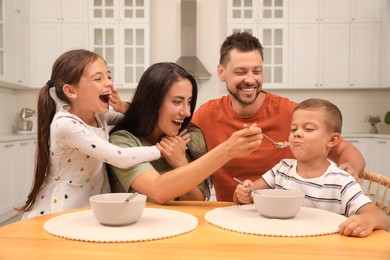 Photo of Happy family with children having fun during breakfast at home