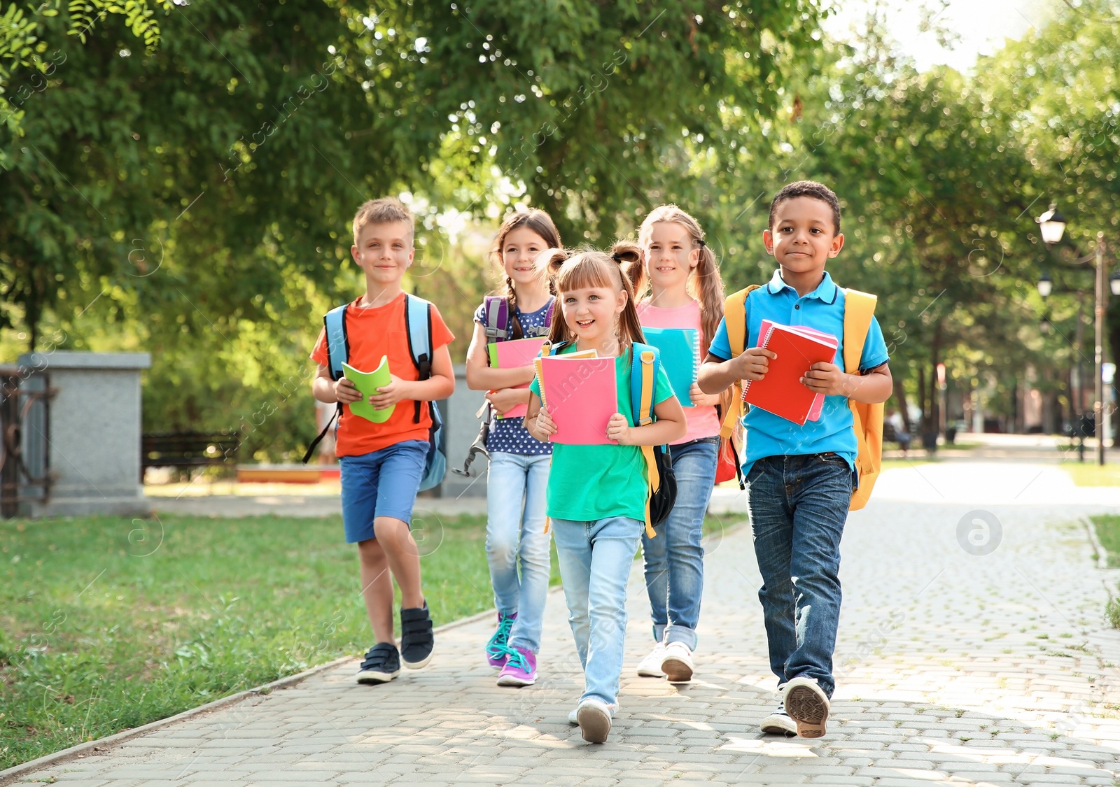 Photo of Cute little children with backpacks going to school