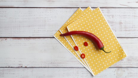 Photo of Pepper plasters and chili on white wooden table, top view. Space for text