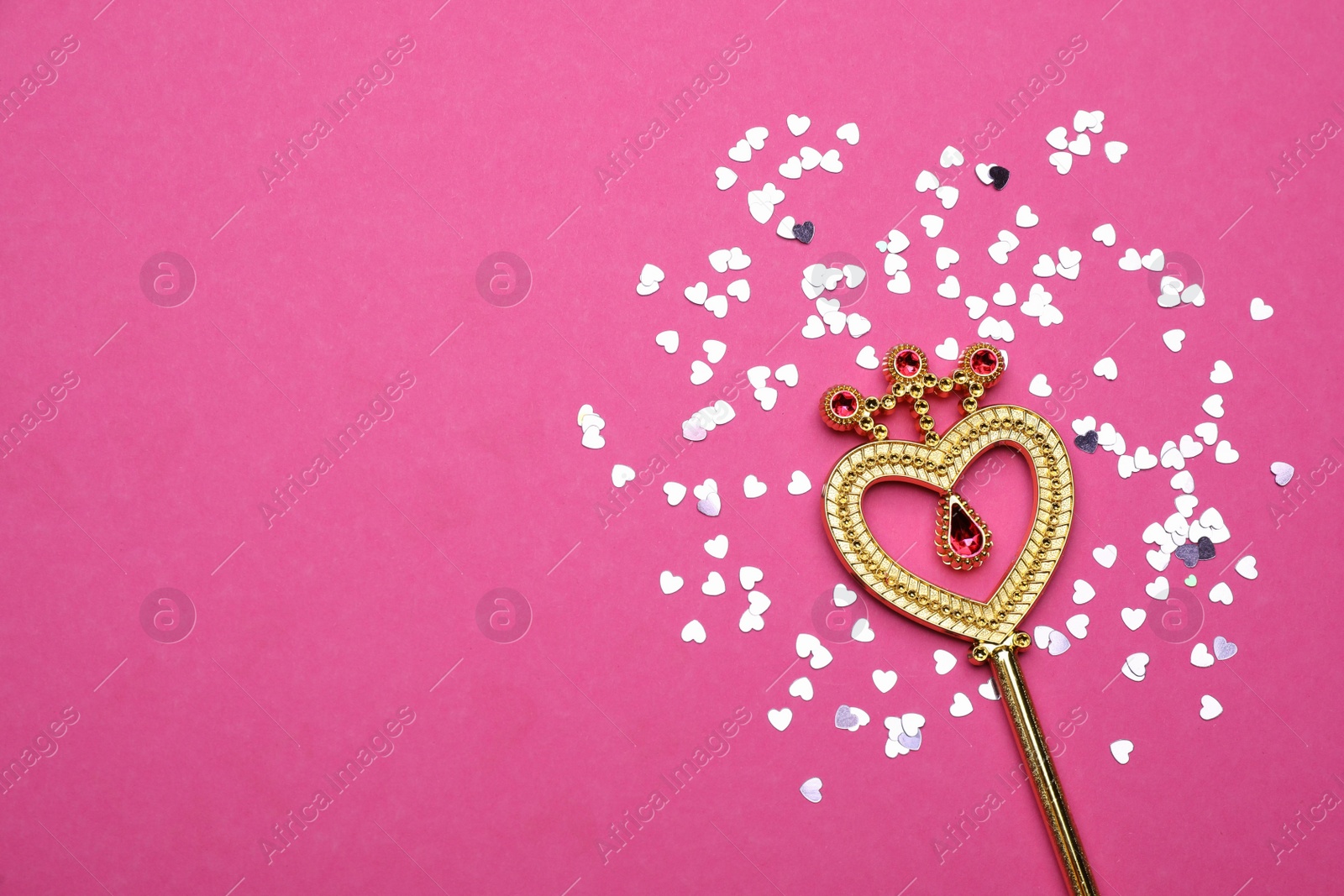 Photo of Beautiful golden magic wand and confetti on magenta background, flat lay. Space for text