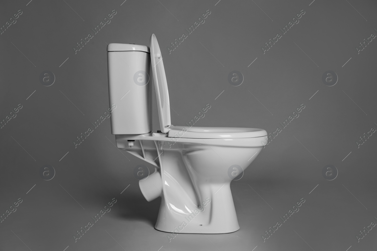 Photo of New ceramic toilet bowl on grey background