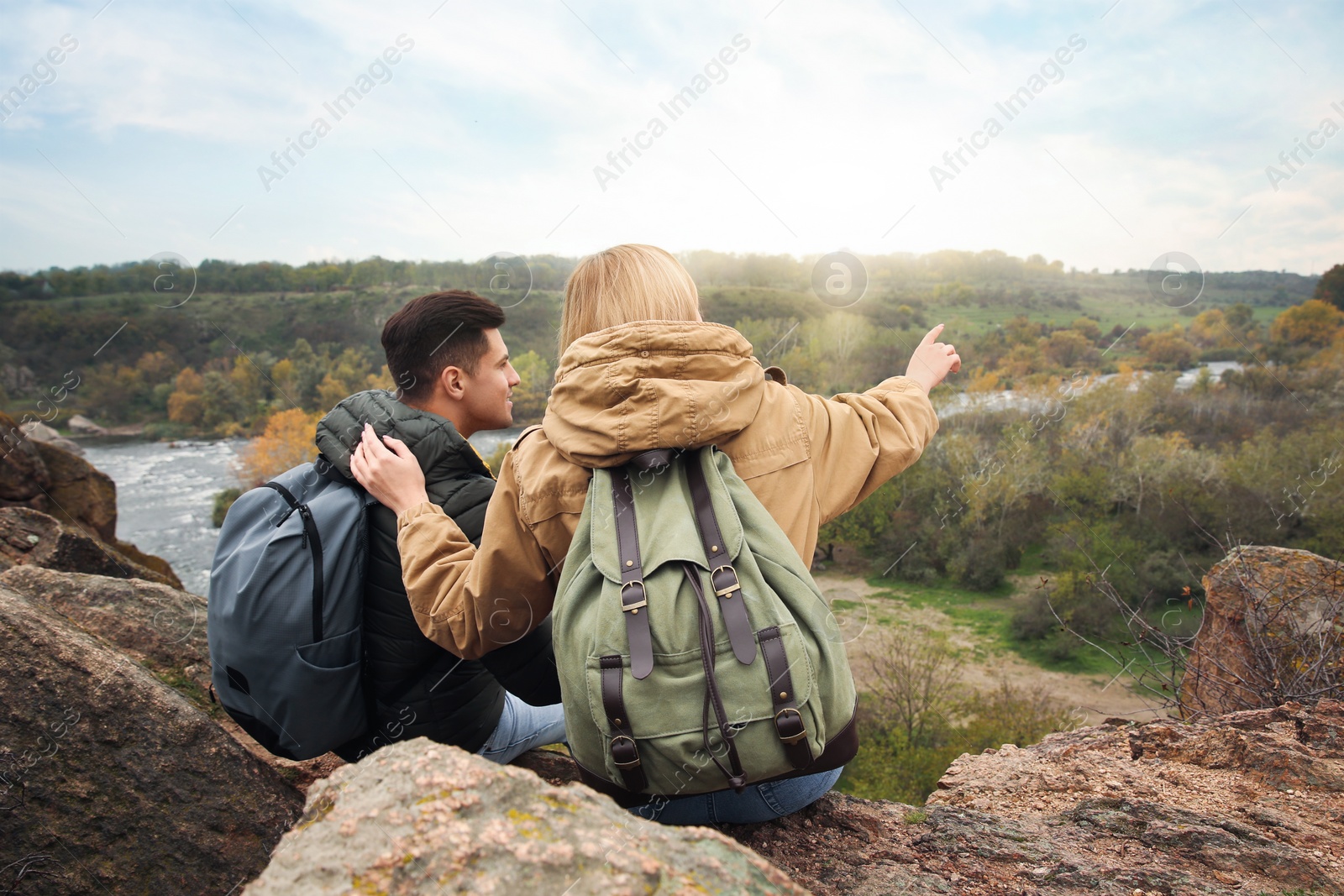 Photo of Couple of hikers with travel backpacks enjoying beautiful view of nature