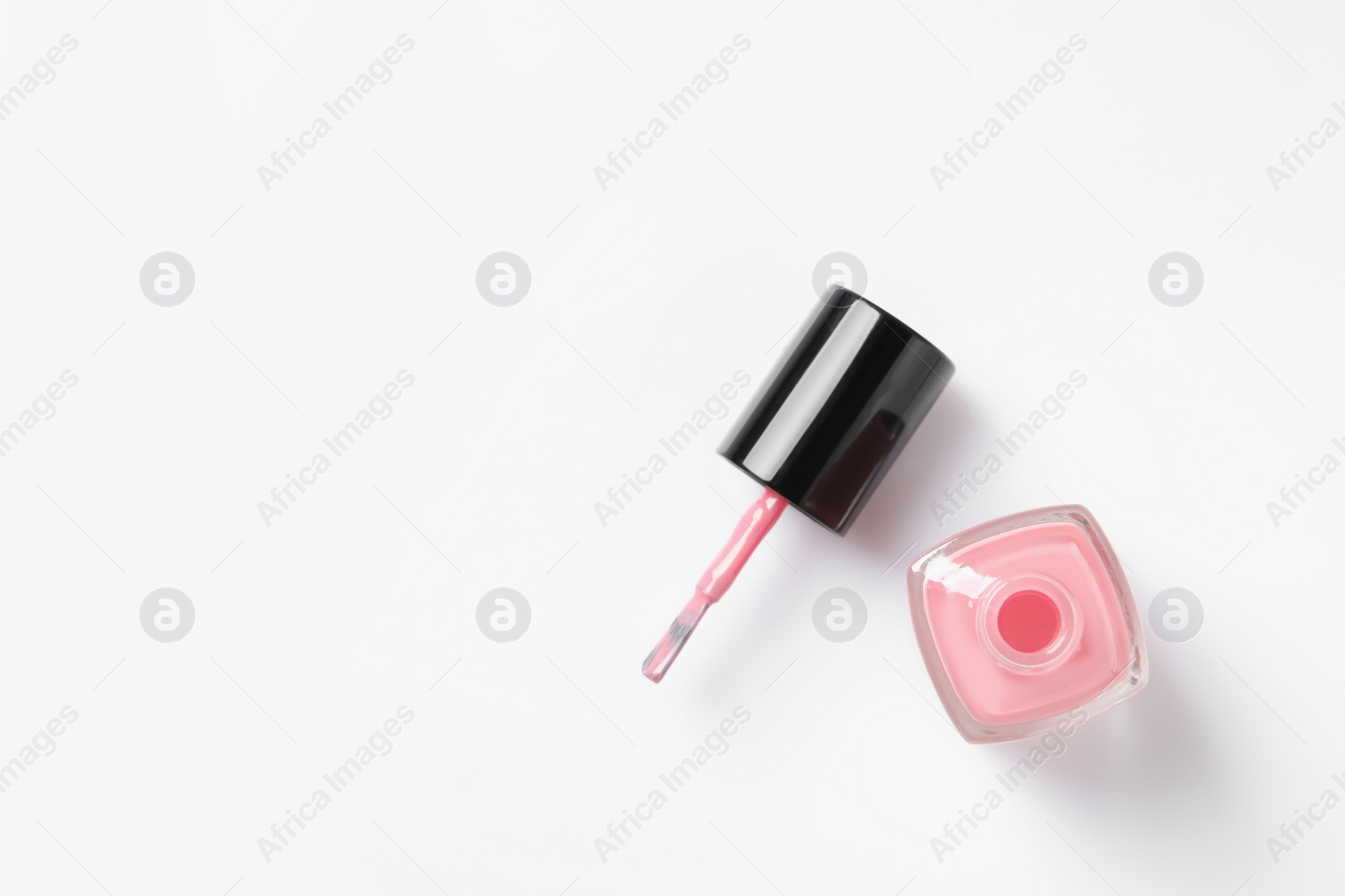 Photo of Bottle of color nail polish with brush on white background, top view