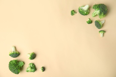 Photo of Flat lay composition with fresh green broccoli on color background. Space for text